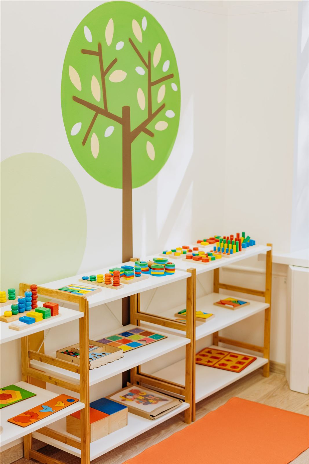 Low, open-faced wooden shelving with Montessori materials organised and ready for children to choose independently